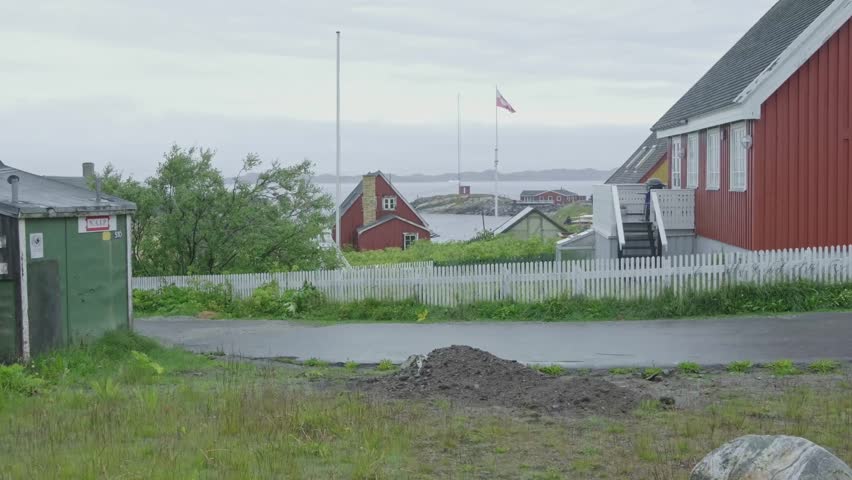 Nuuk the capital of Greenland is full of colorful homes and green vegetation during summer. Iconic greenland flag flying.