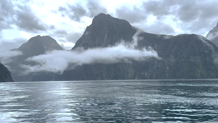 Dramatic mountain peaks, steep cliffs in Milford Sound, over the water. New Zealand nature