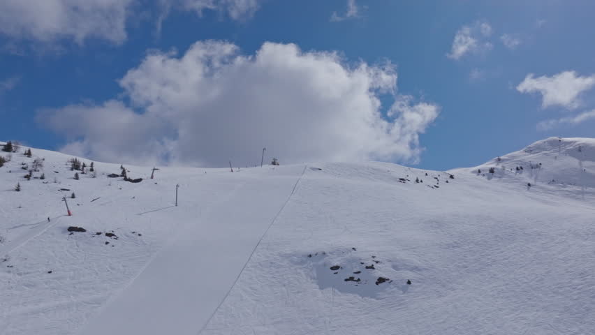 High performance alpine ski carving on groomed pistes in Verbier Bruson and Val de Bagnes filmed with drone and follow cam on a bluebird winter day showcasing fast dynamic fun skiing.