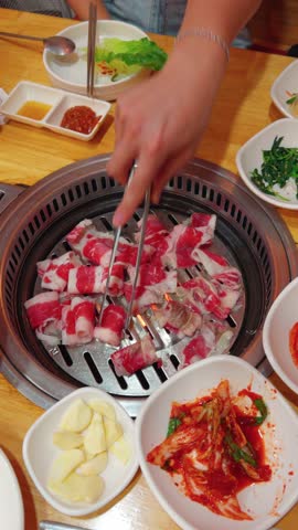 Evening Grilling at a Korean BBQ Restaurant, Featuring Marinated Meat and Side Dishes