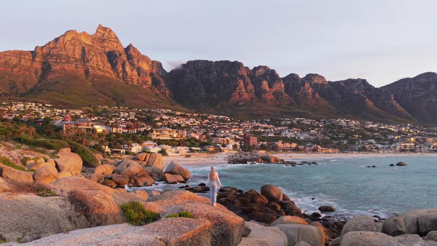 Sunset Over Camps Bay Beach in Cape Town, South Africa, Featuring Table Mountain and Coastal Rock Formations