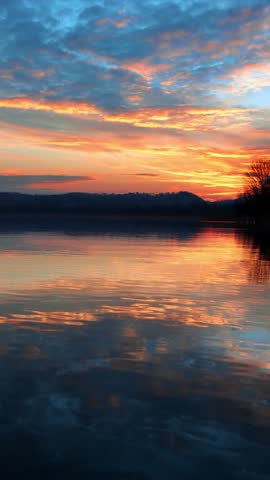 Vibrant Sunset Over Calm Lake With Colorful Cloud Reflections