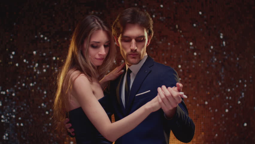 Couple dancing slow dance. Man holding woman hand, celebrating Christmas. Male and beautiful woman have a romantic party and evening. Waltz music. Cute girl and handsome guy. Holiday and vacation.