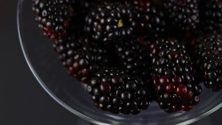 black berries rotating over gray backdrop, close-up. Macro shot. Market. Vegan food, macro shot 4k