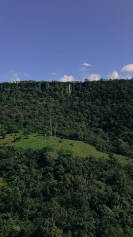 A lush green hillside with a tall tower in the distance