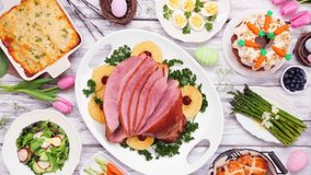 Classic Easter ham dinner. Slow rotating zoom motion. Overhead view table scene on a white wood background. - Powered by Shutterstock - Get 15% off with code: PIKWIZARD15