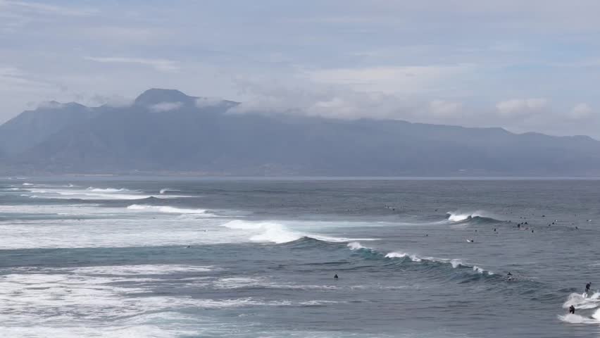 Surfers floating on large waves off the northern coast of Maui