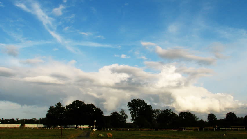 Rainbow and storm clouds over blue sky, time lapse clip