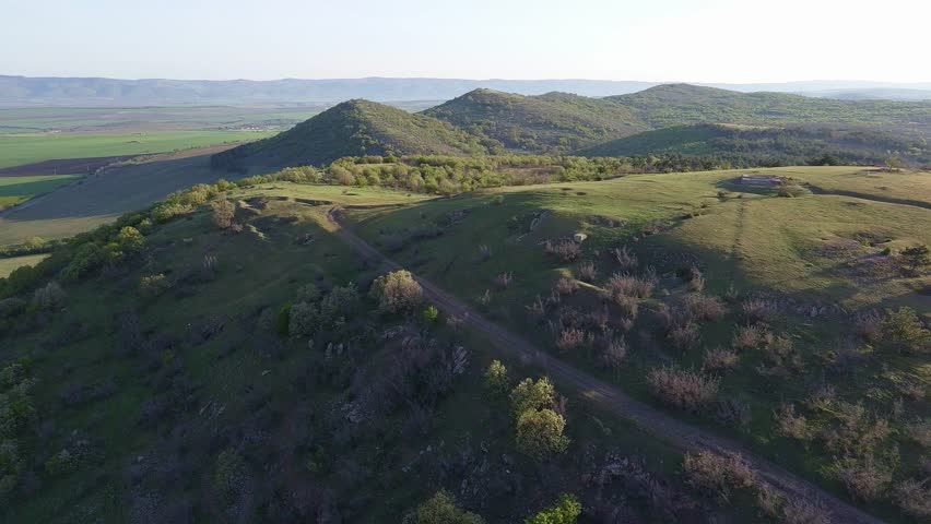 A view from a height of the meadows and slopes of the Balkan Mountains under daylight in Bulgaria
