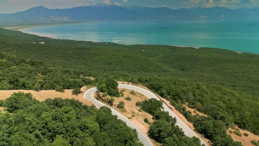 Aerial drone footage of Lake Prespa in North Macedonia. Scenic view of a large freshwater lake surrounded by mountains and natural landscape. Peaceful protected area in the Balkans, known for rich wildlife, wetlands and unspoiled nature.