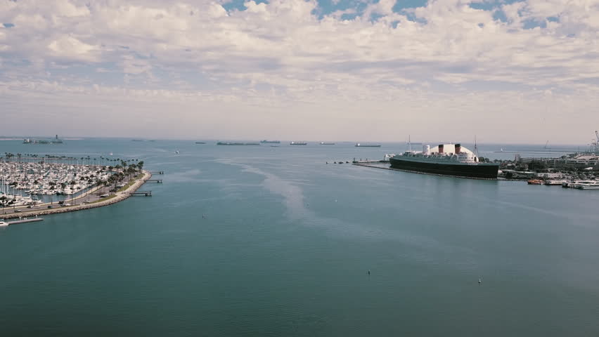 Queen Mary in Long Beach Harbor with boats and Lighthouse, Blue Sky and Clouds, California, 4K Aerial, Los Angeles and Southern California Beaches