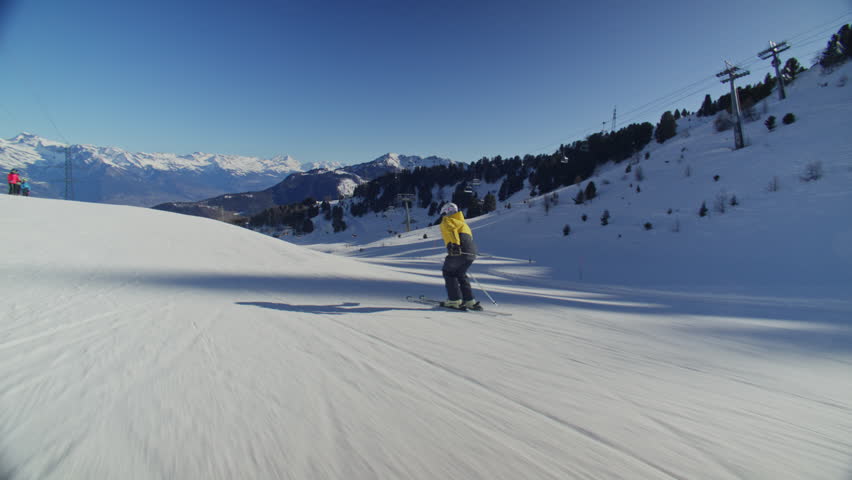 High performance alpine ski carving on groomed pistes in Verbier Bruson and Val de Bagnes filmed with drone and follow cam on a bluebird winter day showcasing fast dynamic fun skiing.