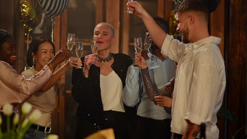 Cheerful multiethnic friends clinking glasses and drinking sparkling wine. Happy people celebrating a special occasion with a toast