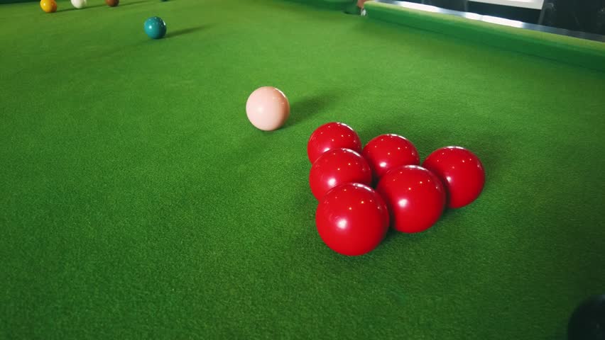Close-Up View of Snooker Balls on Green Felt Table with Focus on Red Balls Ready for a Game of Snooker with a Cue Ball in the Background