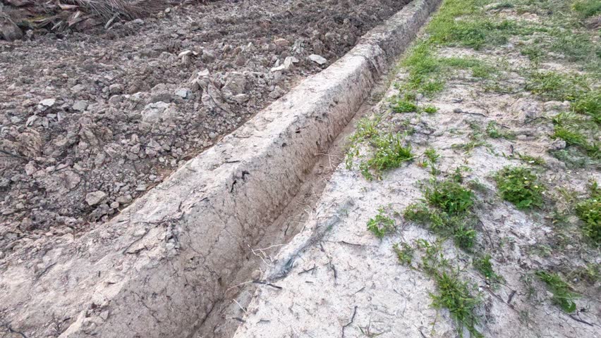 scene of a simple man made drainage system on a newly plough land.