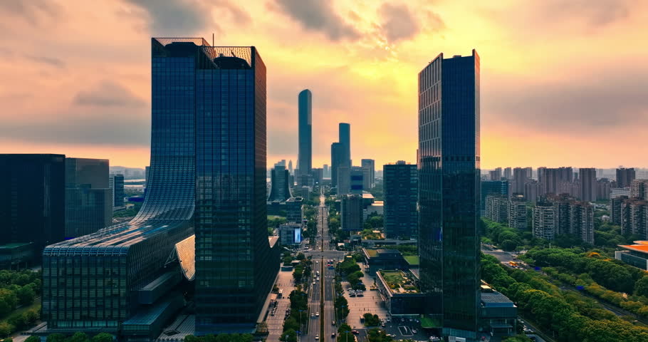 Aerial shot of modern skyscrapers and city skyline in Suzhou, China during a golden sunset.