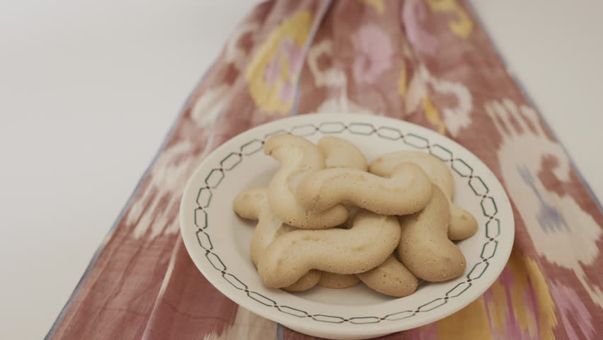 Putting on table three  cups of coffee, in the foreground a plate with biscuits ,  ,taking a break and socializing 