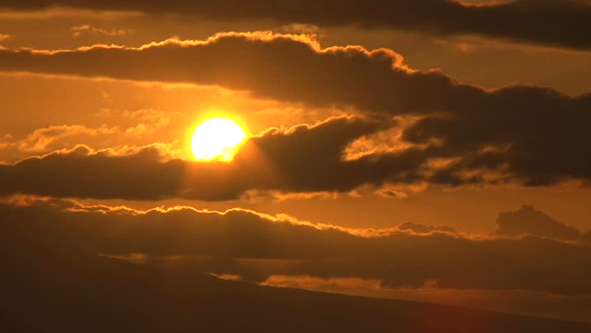 Time lapse with sun setting behind clouds, close up.