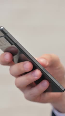 Vertical video, Close up of Businessman Hand Using Smartphone in Office