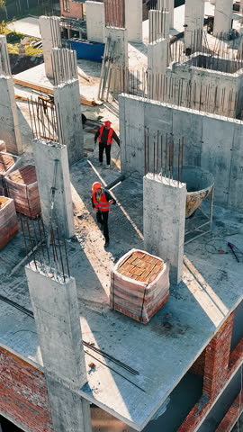 Aerial view Construction works. Builders are building another floor of a multi-story brick building.