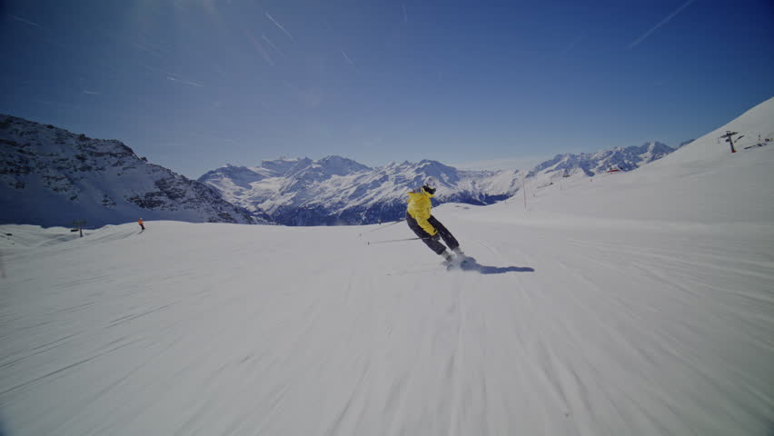 High performance alpine ski carving on groomed pistes in Verbier Bruson and Val de Bagnes filmed with drone and follow cam on a bluebird winter day showcasing fast dynamic fun skiing.