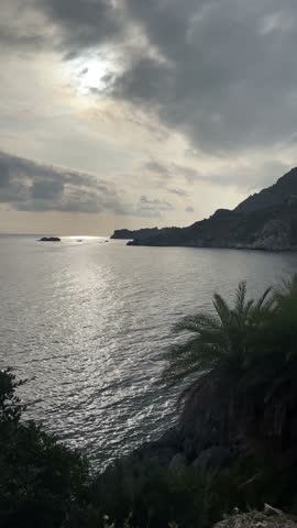 Vertical shot: crystal clear deep turquoise water at Plakias and Souda beach, southern Crete coast with rocky cliffs, beautiful mediterranean nature, greek summer