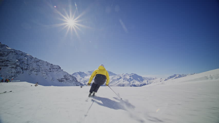 High performance alpine ski carving on groomed pistes in Verbier Bruson and Val de Bagnes filmed with drone and follow cam on a bluebird winter day showcasing fast dynamic fun skiing.