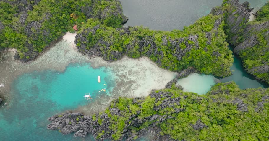 Aerial view of lagoons with boats surrounded by splendid limestone rock formations in Miniloc Island. El Nido, Philippines. Palawan.
