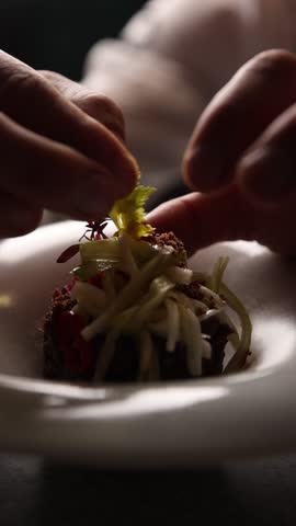 The chef decorates dishes in the restaurant. Close-up.