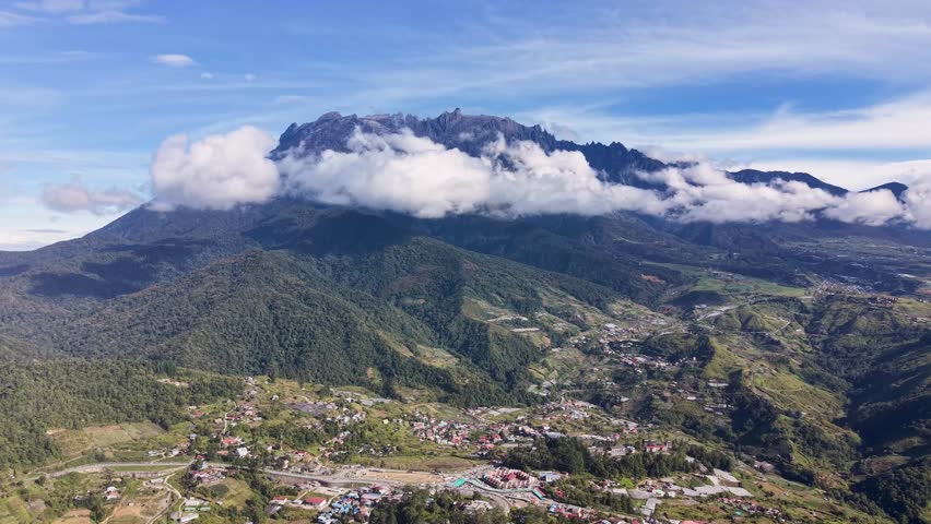 Mount Kinabalu rising through the clouds - a granite giant holding Sabah’s sky in its hands, where every step feels like walking toward the edge of the world	