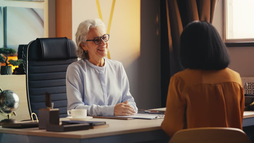 Senior woman recruiter shaking hand with female applicant, hiring employee
