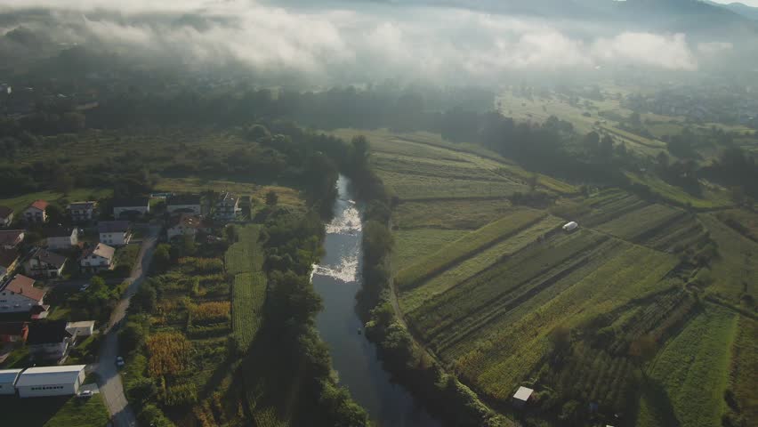 Soft morning fog drifting across a peaceful landscape at sunrise, creating a calm atmospheric scene with mist, nature beauty, and tranquil mood.
