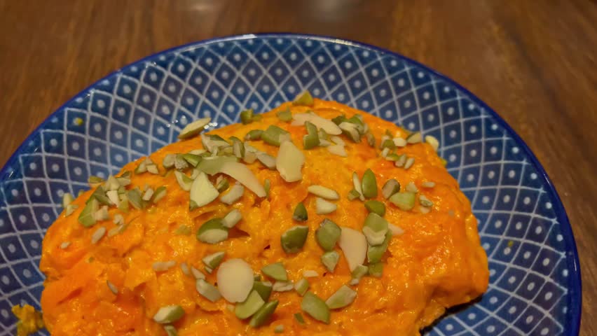 Close-up of gajar ka halwa, a traditional Indian carrot dessert, served in a bowl and garnished with nuts. Popular sweet dish prepared during festivals, celebrations, and family meals
