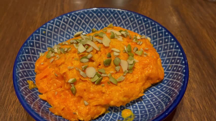 Close-up of gajar ka halwa, a traditional Indian carrot dessert, served in a bowl and garnished with nuts. Popular sweet dish prepared during festivals, celebrations, and family meals