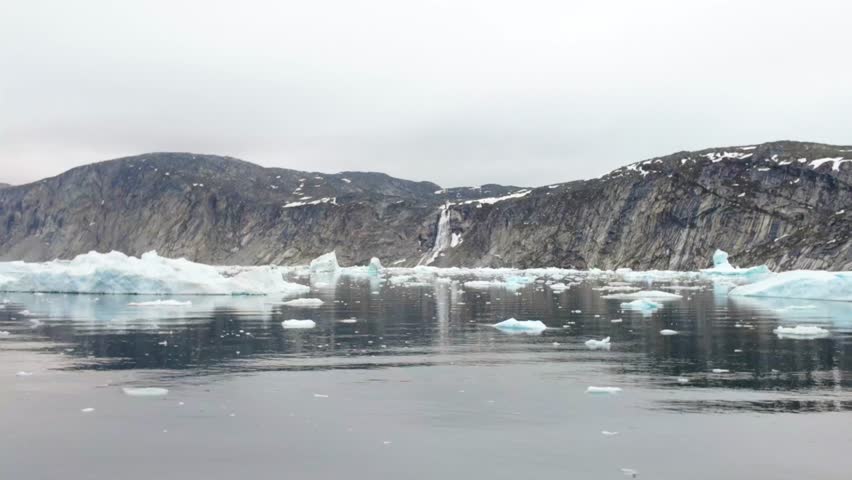 Arctic landscape with icebergs and waterfall in Greenland