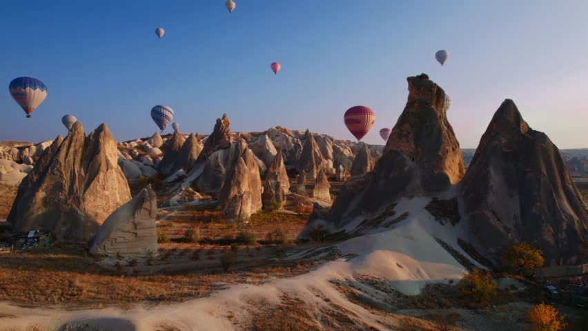 Aerial view Landscape sunset in Cappadocia, travel tour excursion on horse with hot air balloons in Goreme Turkey.