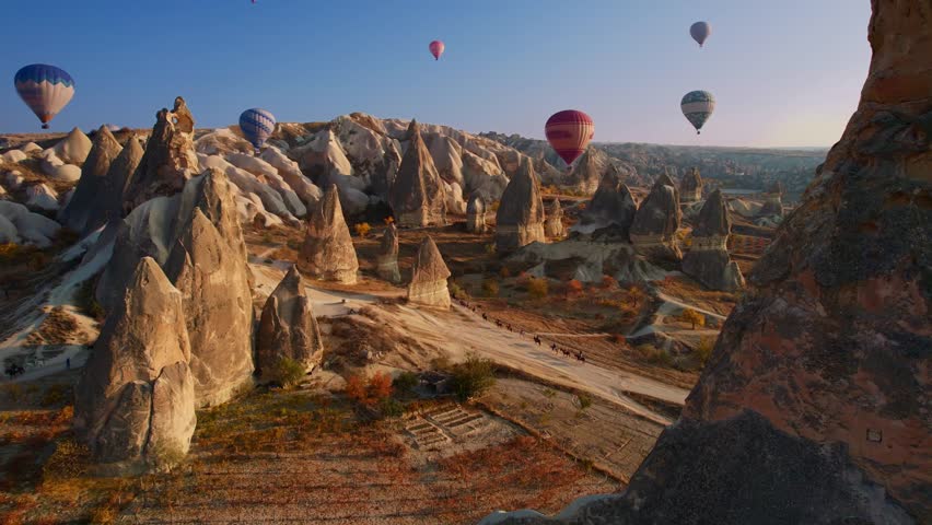 Travel tour excursion on horse with hot air balloons in Cappadocia, Goreme Turkey, Aerial view sunset time.