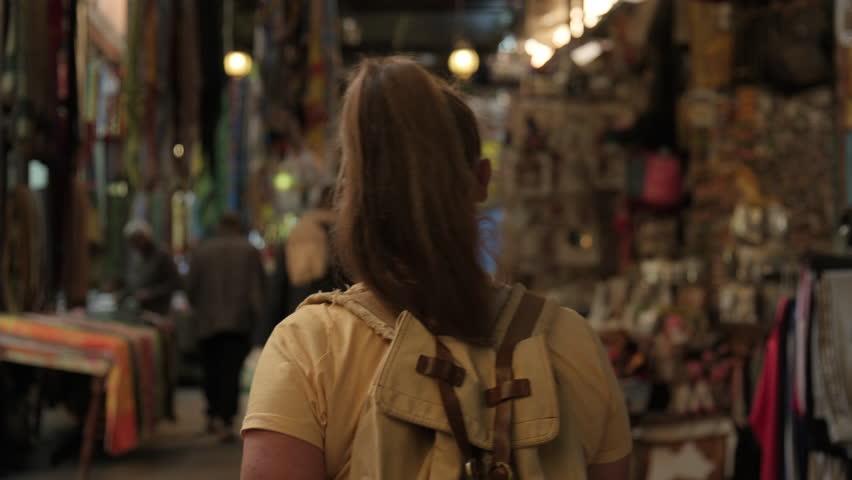 European woman tourist exploring while walking through El Souk market in Luxor