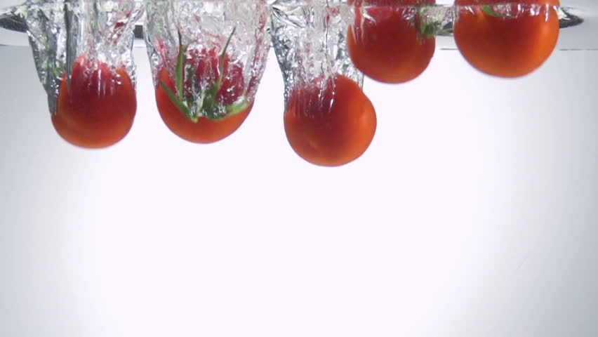 Fresh tomato dropped into water with bubbles