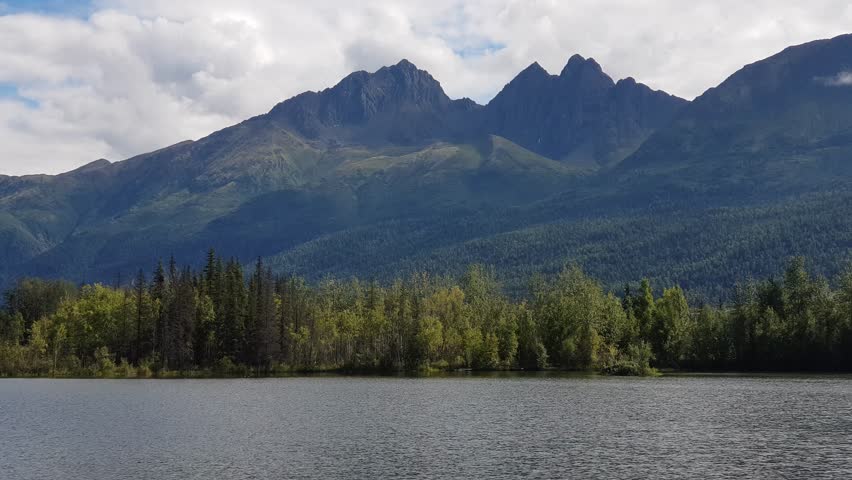 Beautiful view of Reflections Lake and mountains next to Glenn Highway in Alaska