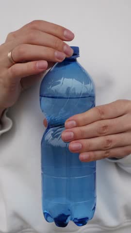 Close-Up of hand opening PET Bottle cap, recycling process - vertical view