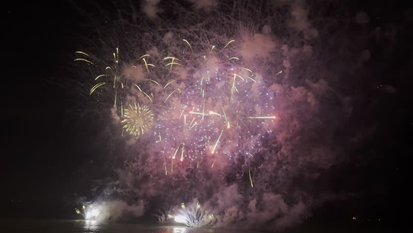 Spectacular fireworks burst in a kaleidoscope of colors against the darkened sky, captivating viewers during the local celebration. The explosions create a lively atmosphere filled with excitement.