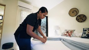 Professional chambermaid carefully folding a towel on a freshly made bed. Diligent hospitality worker providing excellent room service - Powered by Shutterstock - Get 15% off with code: PIKWIZARD15