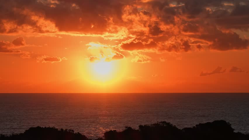 Sunset over the Sea Time-Lapse. Red Sun Setting Over Calm Sea Horizon at Sunset Time Lapse. Scenic Seascape with Bright Red Sun at Dusk TimeLapse. Golden Evening Sky and Red Sun Above Tranquil Sea