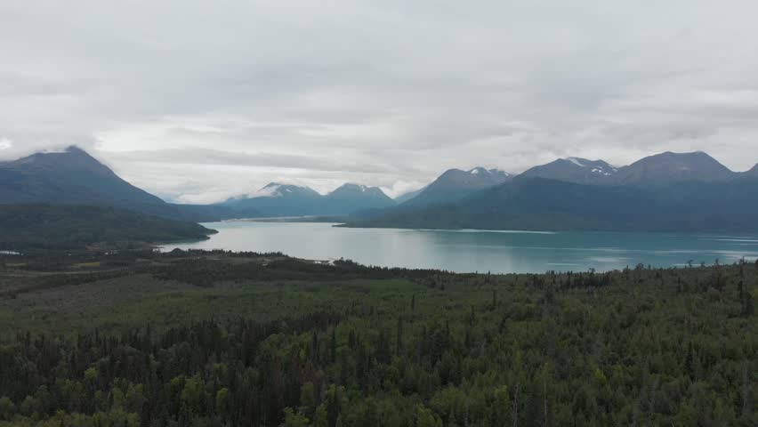 Aerial view of Skilak Lake and Alaskan wildernes with tress and mountains near Seward Highway, dolly filming