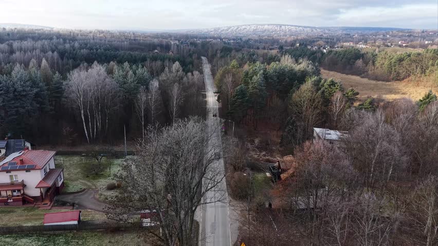 Aerial view of winter road through pine forest and Distant Hills in Poland