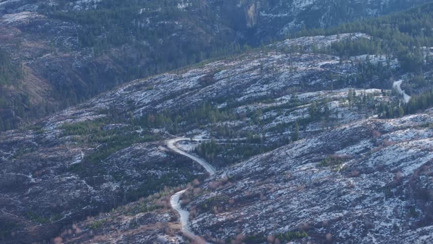 Snow covered mountain road winding through trees