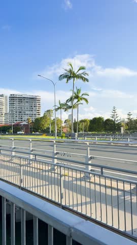 A colorful amphibious tour vehicle drives across a bridge under bright sunlight in Queensland