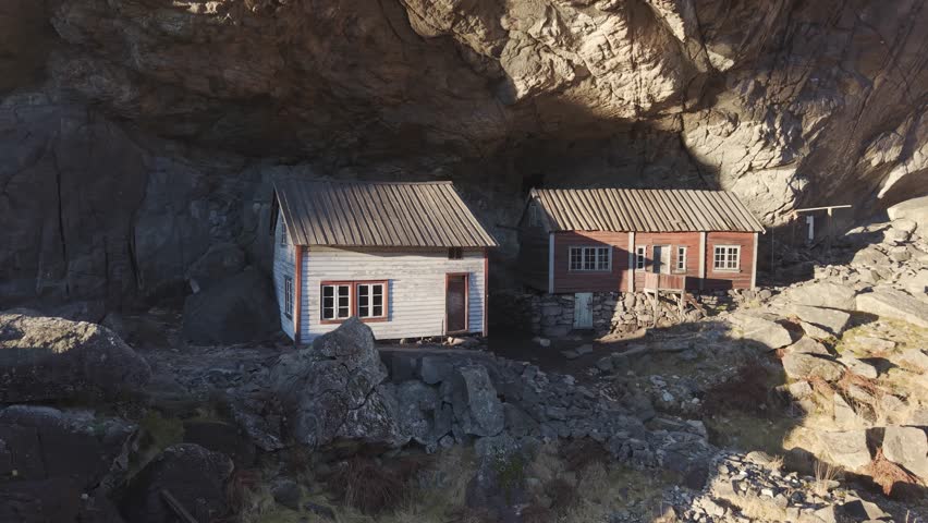 Two old houses under a cliff in Norway. Drone footage