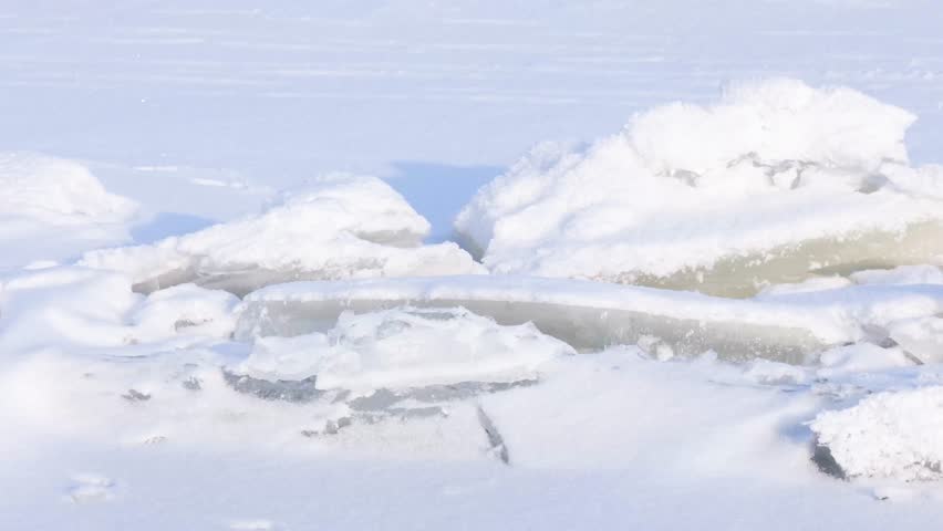 Detailed natural winter landscape featuring large fractured ice blocks covered completely with pristine white snow
